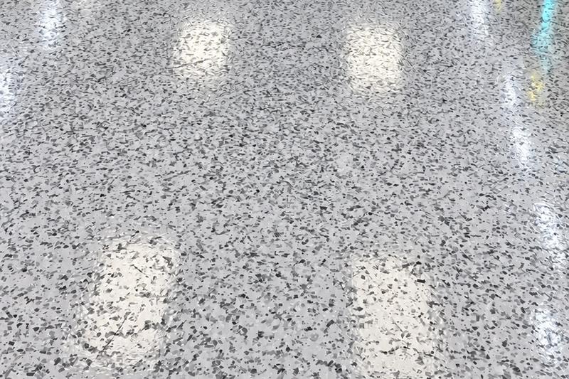 Full-broadcast flake floor with polyaspartic topcoat